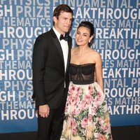 Malam itu, Mila tampak anggun dalam balutan gaun floral dengan bodice korset Dolce & Gabbana. Sementara Ashton gagah dengan tuksedo hitam. (Foto: Jesse Grant/Getty Images)