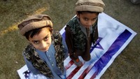 Anak-anak berdiri dan menginjak-injak bendera A.S. dan Israel sebagai bentuk protes terhadap Presiden AS Donald Trump bahwa dia telah mengakui Yerusalem sebagai ibu kota Israel, di Islamabad, Pakistan pada tanggal 7 Desember 2017. REUTERS / Caren Firouz