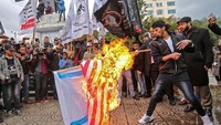 Warga yang protes juga membakar bendera AS (Foto: AFP PHOTO / MAHMUD HAMS)