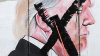 Seorang pria Palestina melintasi sebuah mural yang menggambarkan Presiden A.S. Donald Trump yang dilukis di bagian penghalang Israel, di kota Bethlehem, Tepi Barat, 7 Desember 2017. REUTERS / Mussa Qawasma