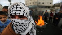 Seorang warga Palestina bertopeng mengambil bagian dalam sebuah demonstrasi menentang keputusan Presiden AS Donald Trump untuk mengakui Yerusalem sebagai ibukota Israel, di Khan Younis di Jalur Gaza selatan. REUTERS / Ibraheem Abu Mustafa
