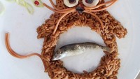 Nasi merah yang disandingkan dengan ikan ternyata bisa disajikan dengan cara unik. Dibentuk jadi kucing, ikan goreng ini seolah-olah sedang berada di dalam perutnya. Sedangkan kumisnya dibentuk dari spaghetti. Nyam! Foto: Foivi Geller