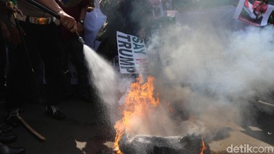 Foto: Polisi Padamkan Ban yang Dibakar Massa di Kedubes AS