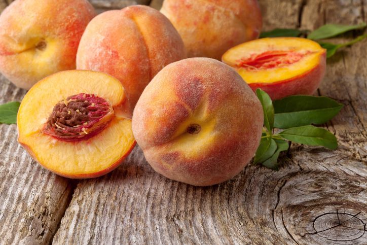 Group of fresh peaches on wooden background