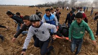 Demonstran membantu mengevakuasi rekannya saat terlibat bentrok dengan tentara Israel di Gaza City. 7 Desember 2017 (Foto: Dok. REUTERS/Ibraheem Abu Mustafa)
