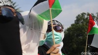 Dalam aksi ini massa juga membawa bendera Palestina.