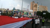 Sementara itu aksi protes di Semarang, massa membentangkan bendera merah putih sepanjang 1,5 km dan mengibarkan bendera Palestina.  (Foto: Angling Adhitya Purbaya)