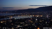 Sambil ngobrol, nikmatilah keindahan Teluk Lalong dari kejauhan. Teluk ini seperti berpendar diterpa cahaya lampu bangunan-bangunan di sekelilingnya. (Wahyu/detikTravel)