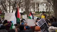 Selain salat berjamaah, warga muslim AS ini juga membawa poster yang isinya mengecam pendudukan Israel atas Yerusalem Timur dan Tepi Barat. Foto: AFP PHOTO/Mari Matsuri