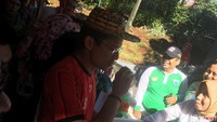 Sandiaga mengenakan topi rajutn dan minum di dalam stan OK OCE. (Arief Ikhsanudin/detikcom)