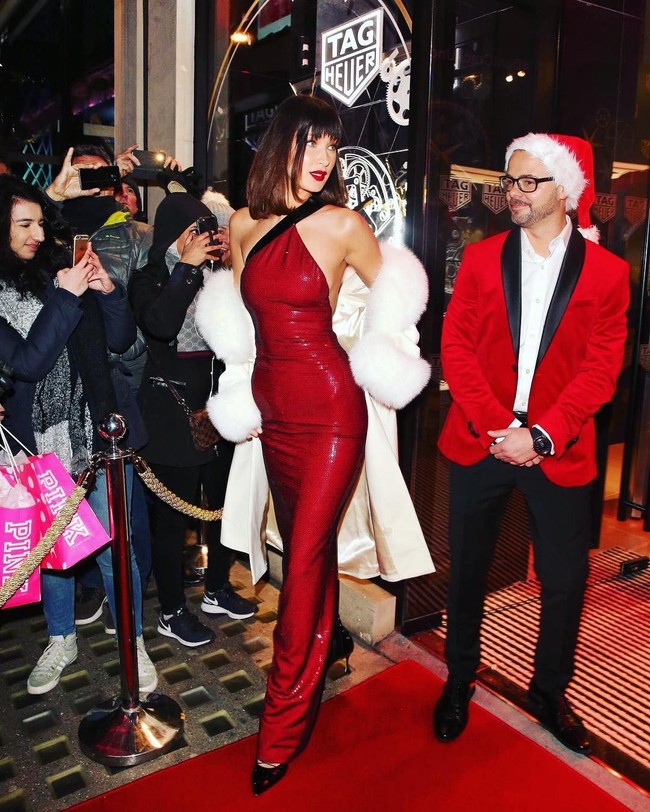 Sosok Bella Hadid muncul di tengah akis unjuk rasa di jalanan London, Inggris, Sabtu (10/12/2017). Adik Gigi Hadid itu terlihat dalam balutan gaun merah sequin asimetris yang berkilauan dengan coat beraksen bulu sebagai luaran. Foto: Dok. Instagram