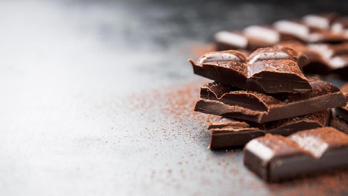 Chocolate background. Many pieces of chocolate, candies, cookies, biscuits, cakes and other sweets. Milk chocolate and dark chocolate. coconut candy