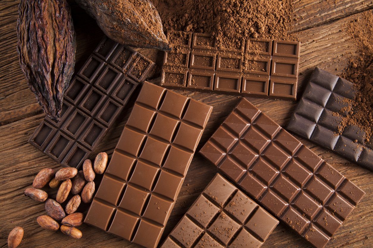 Chocolate background. Many pieces of chocolate, candies, cookies, biscuits, cakes and other sweets. Milk chocolate and dark chocolate. coconut candy