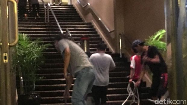 Para petugas sedang mengeringkan lantai