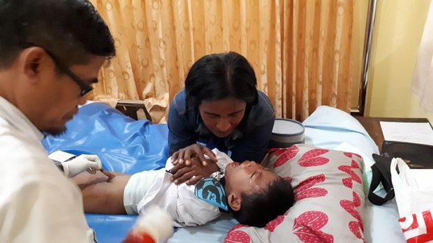 Orang tua menenangkan anaknya yang hendak dikhitan