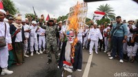 Api kemudian melahap boneka bertopeng Trump tersebut.