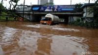 Hanya kendaraan besar dan tinggi yang berani melintasi banjir tersebut.