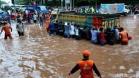 Akibat genangan itu, banyak kendaraan tak bisa melintas. Terlihat sejumlah orang mendorong truk. Sementara di bagian sisi jalan yang lain sejumlah pengendara motor melihat genangan tersebut. (Foto: Ari Saputra/ detikcom)
