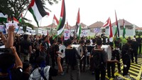 Massa juga mengibarkan bendera Palestina dan membentangkan poster tuntutan.
