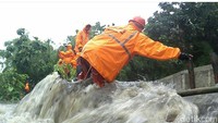 Petugas PPSU menahan tanggul sementara secara manual untuk mengurangi jebol yg semakin meluas (Foto: Dok. BPBD DKI)