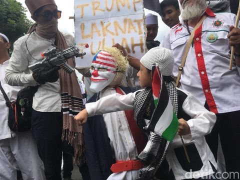 Boneka tersebut sempat diarak massa. Seorang bocah juga sempat memukul boneka tersebut