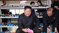 Oktober 2017: Kim Jong-Un bersama istrinya, Ri Sol-Ju, mengunjungi pabrik sepatu Ryuwon pada awal Oktober lalu. Dia mengamati para pekerja membuat sepatu dan melihat-lihat sepatu anak-anak. Sang istri tampak melihat-lihat sepatu di belakang Kim. Foto: KCNA