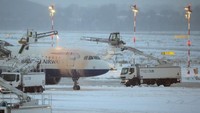 Bandara Duesseldorf, Jerman juga ditutup selama 4 jam karena cuaca buruk. Terlihat dalam foto, sebuah pesawat sedang dibersihkan dari salju yang menempel di badannya. Foto: AFP PHOTO/DPA/David Young