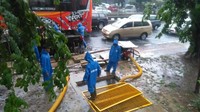 Pasukan biru langsung beraksi untuk menyedot air yang mulai menggenangi jalan. Mereka beraksi ditengah guyuran hujan deras.