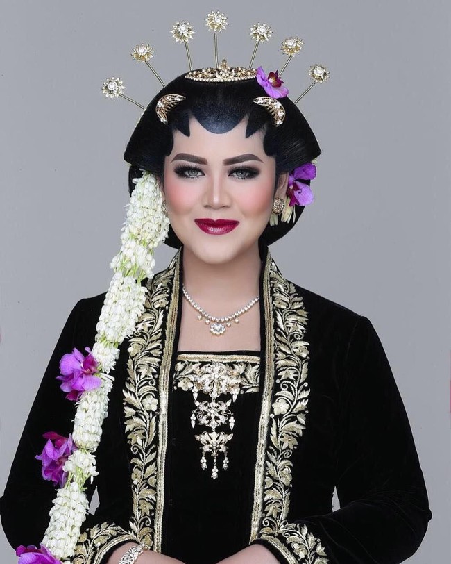 Dengan kebaya pengantin Solo Basahan, Kahiyang tampil manglini dengan makeup yang dirias oleh Bennu Sorumba. Dengan lipstik merah keunguan, alis on-fleek dan menggunakan softlense, Kahiyang Ayu tampil sangat cantik. Penampilannya ini bukanlah foto throwback saat dia menikah. Namun Kahiyang dimanta oleh makeup artist Benny Sorumba menjadi model untuk buku makeupnya.  Foto: dok. Instagram (Bennu Sorumba)