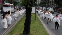 Pemandangan jalanan Kota Bangkok pun jadi agak berbeda pada Sabtu (2/12) lalu. Banyak mempelai berlarian di sana. Bukan karena mengejar penghulu, tetapi demi menang lomba. (Athit Perawongmetha/Reuters)