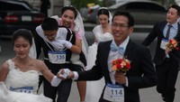 Perlombaan ini diberi nama Running of The Brides alias Calon Pengantin yang Lari. Syarat mengikuti lomba ini cukup mudah, yang penting mengenakan gaun dan jas pengantin lengkap. (Athit Perawongmetha/Reuters)
