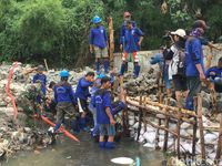 Petugas menangani tanggul Kali Pulo yang jebol dan bikin banjir