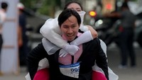 Tak jarang ada mempelai wanita yang tidak sanggup berlari lagi. Kalau sudah begini, mau tak mau suami menggendong wanita yang dicintainya di pundak. Ayo semangat mas! (Athit Perawongmetha/Reuters)