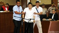 Tersangka korupsi e-KTP  itu dipapah saat akan duduk ke kursi terdakwa.