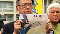 Gubernur Okinawa Takeshi Onaga menunjukkan foto jendela yang jatuh dari helikopter militer AS di SD Futenma, Okinawa. Foto: AFP PHOTO/JIJI PRESS
