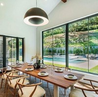 Di samping kolam renang, ada ruang berkaca yang digunakan sebagai ruang makan dengan meja dan kursi kayu. Rumah dengan interior yang didominasi kaca itu terlihat sangat luas dan mewah. Foto: Dok. Trulia