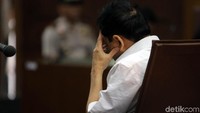 Novanto memegangi kepalanya saat hakim memutuskan untuk melanjutkan sidang ke tahap pembacaan dakwaan (Foto: Agung Pambudhy/detikcom)