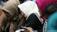 Deisti tampak mengenakan baju warna hitam dengan kerudung krem.