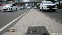 Kendaraan melintasi water inlet yang dibuat oleh kontraktor LRT Adhi Karya dikawasan Kuningan, Jakarta, Kamis (14/12/2017).