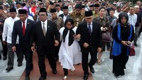 Keluarga dan pelayat berjalan mengiringi peti jenazah menuju liang lahat.