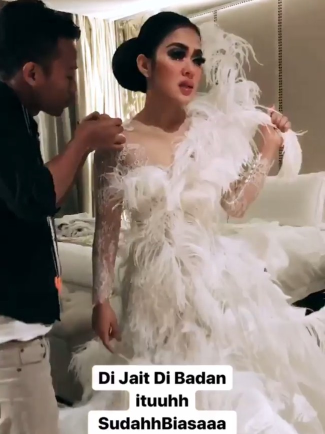 Syahrini sempat mengabadikan sejumlah momen-momen persiapannya di Instagram jelang tampil. Salah satunya ketika tim Eddy Betty menjahit gaun yang sedang Syahrini pakai. Dijahit di badan ituuuhh sudahh biasaa yaa khannn, tulis Syahrini di Instagram stories. (Foto: Instagram/Syahrini)