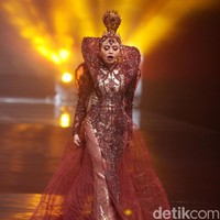 Berwarna coklat seperti tanah, gaun lengan panjang tersebut hadir dengan detail-detail brokat yang memesona. Sebagai pelengkap, rok menerawang yang megar hingga menyapu lantai. (Foto: Mohammad Abduh/Wolipop)