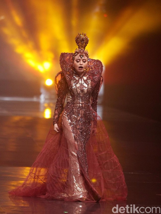 Berwarna coklat seperti tanah, gaun lengan panjang tersebut hadir dengan detail-detail brokat yang memesona. Sebagai pelengkap, rok menerawang yang megar hingga menyapu lantai. (Foto: Mohammad Abduh/Wolipop)