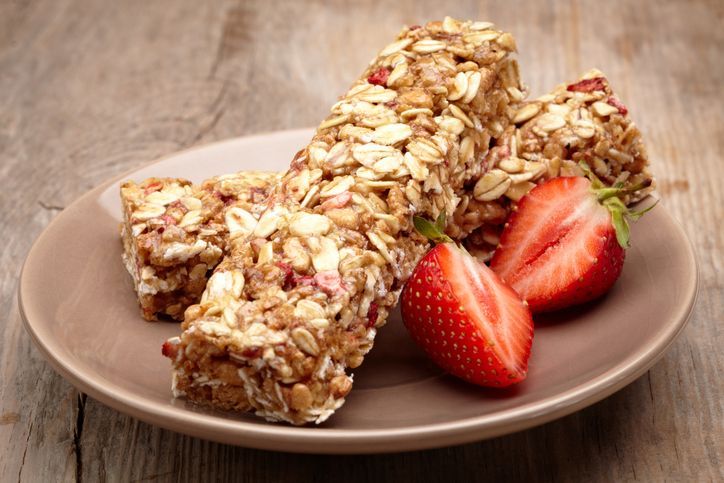 Granola bar and strawberries on plate