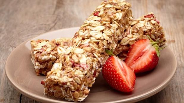 Granola bar and strawberries on plate