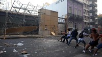 Gagal masuk di depan, demonstran mencoba merobohkan penghalang di pintu samping/Foto: REUTERS/Agustin Marcarian