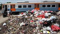 Tumpukan sampah itu berada di dekat perlintasan kereta.