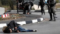 Sedikitnya empat demonstran Palestina tewas dalam bentrokan di Gaza juga Tepi Barat. Dalam foto ini terlihat seorang warga Palestina tergeletak usai ditembak tentara Israel di dekat pos pemeriksaan di Ramallah, Tepi Barat. Demonstran yang memakai sabuk peledak palsu ini akhirnya tewas ditembak. Foto: REUTERS/Goran Tomasevic