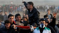 Seorang demonstran Palestina yang mengalami luka-luka dalam bentrokan ini, tengah dievakuasi petugas medis. Foto: REUTERS/Mohammed Salem