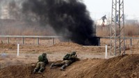 Dua tentara Israel merayap dalam wilayahnya saat bentrokan terjadi dengan demonstran Palestina. Foto: REUTERS/Amir Cohen
